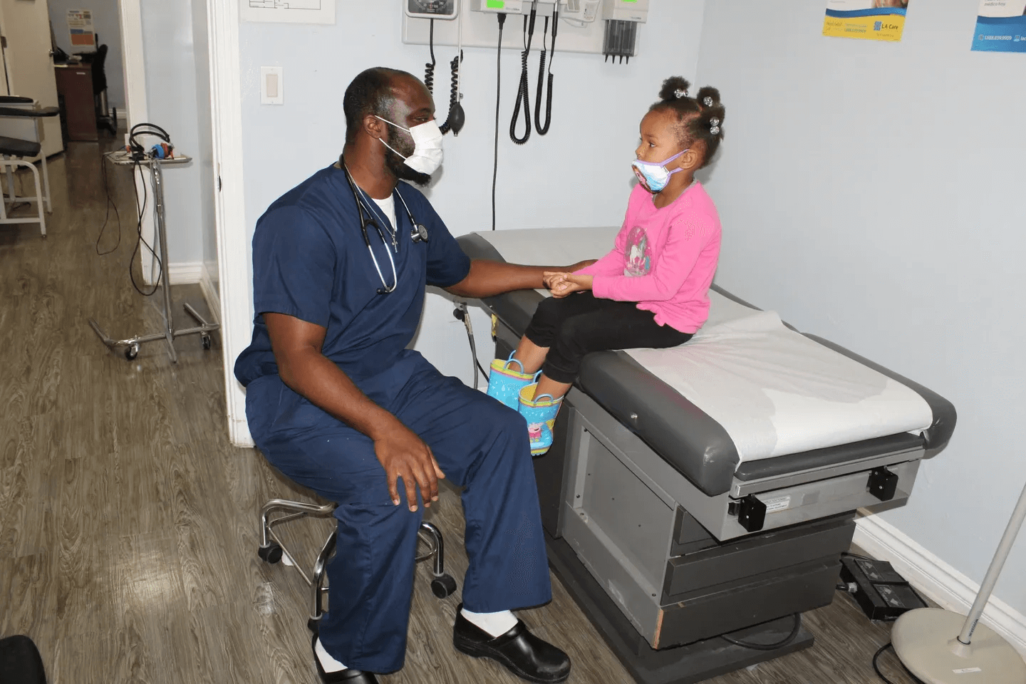 A doctor sitting next to a little girl.