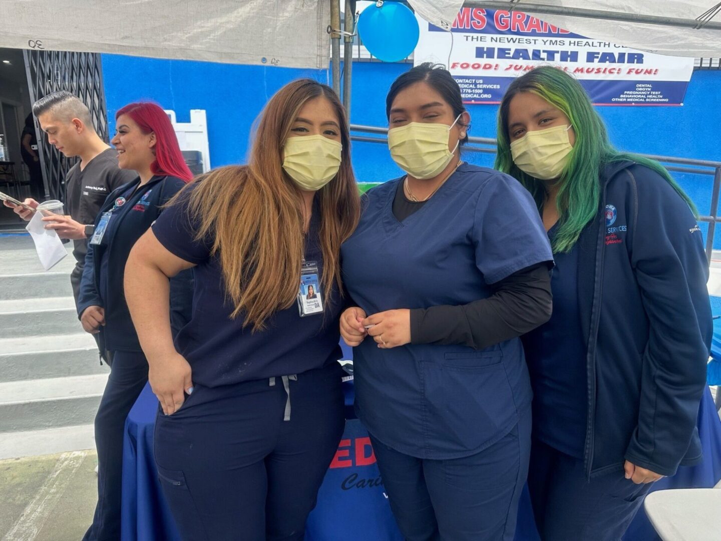 Three nurses wearing masks posing for a picture.